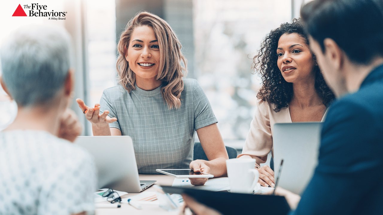 A diverse team in open, engaged conversation around a meeting table